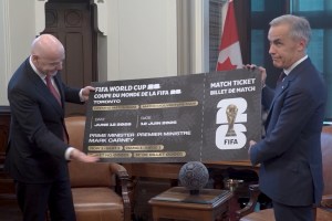 Canadian Prime Minister Mark Carney reacts to FIFA President Gianni Infantino giving him the first ticket to the first 2026 World Cup match in Toronto on June 12, 2026. (FIFA/screenshot)