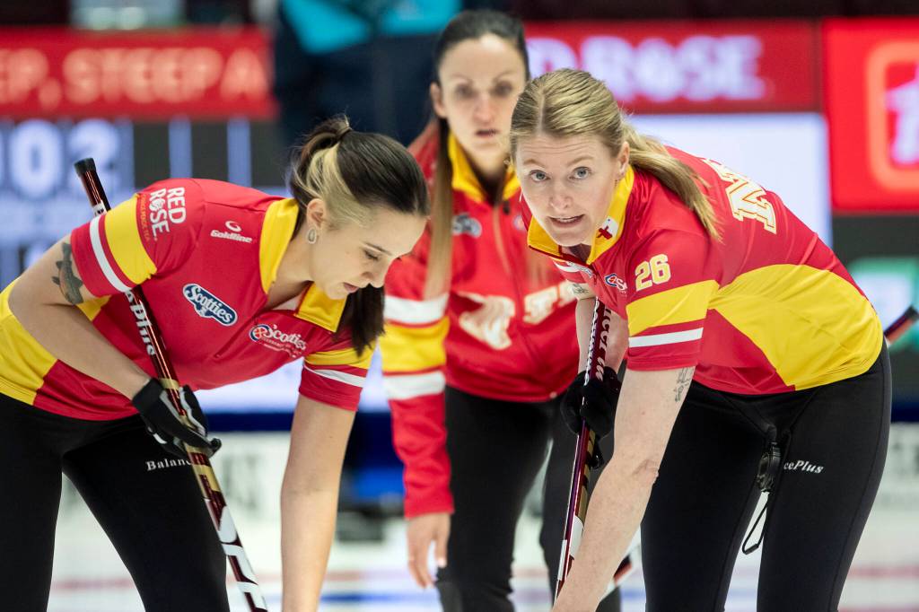 Leigh Gustafson, left, and Alison Taylor put down the brooms on a delivery by skip Julia Weagle. Curling Canada/Andrew Klaver photo